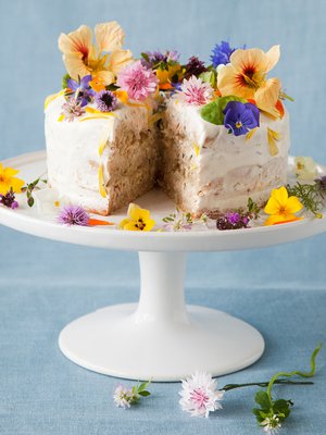 Kukilla koristeltu pyöreä voileipäkakku ei häviä ulkonäössä makeille kakuille. Kuva: <span class="photographer">Arto Vuohelainen</span>