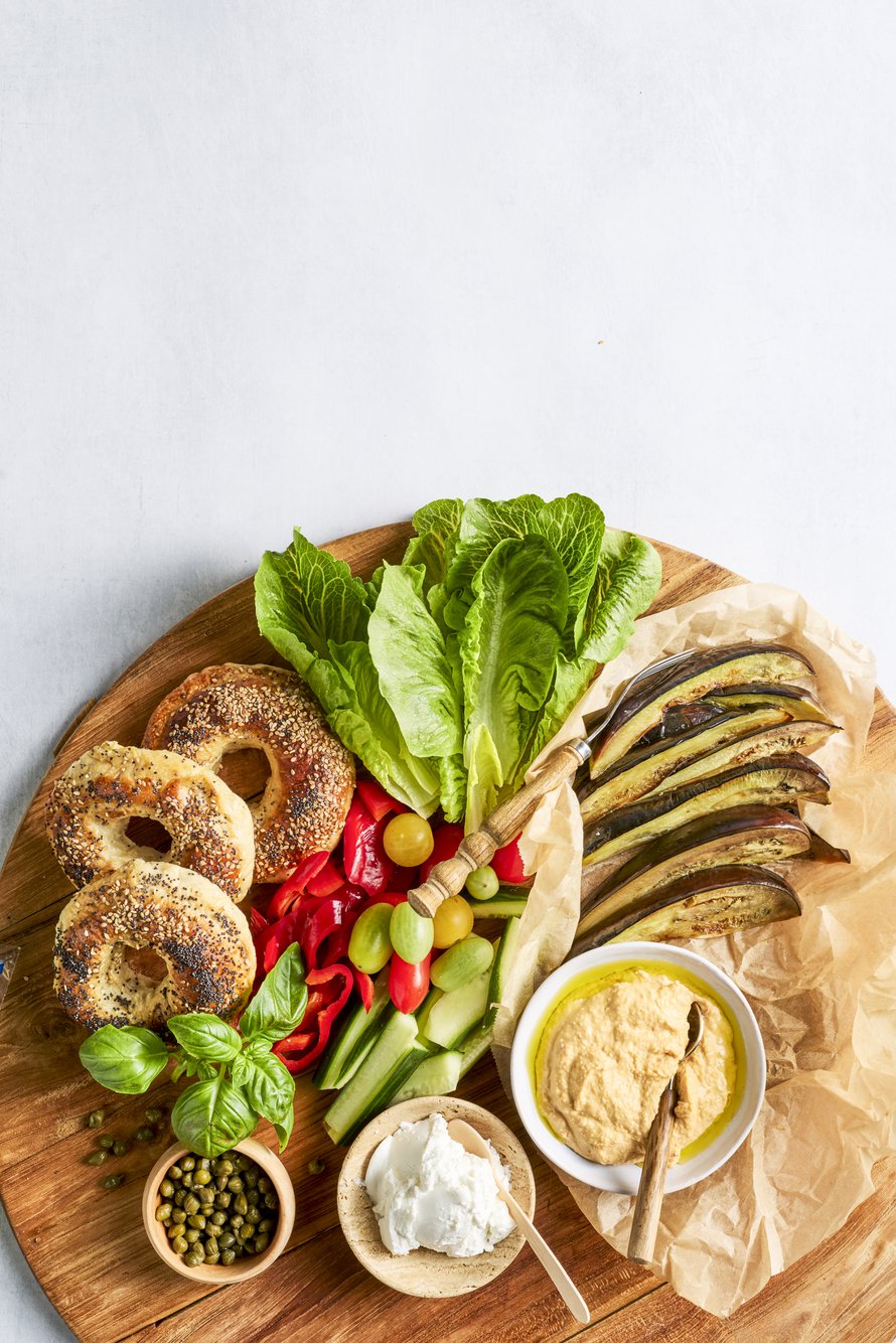 Bagelitarjottimella voi olla vaikkapa pehmeää vuohenjuustoa, hummusta, pannulla paahdettuja munakoisoviipaleita sekä tuoretta kurkkua, tomaattia ja paprikaa.